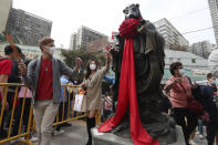 People touch a rat statue as they pray at the Wong Tai Sin Temple, in Hong Kong, Saturday, Jan. 25, 2020 to celebrate the Lunar New Year which marks the Year of the Rat in the Chinese zodiac. China's most festive holiday began in the shadow of a worrying new virus Saturday as the death toll surpassed 40, an unprecedented lockdown kept 36 million people from traveling and authorities canceled a host of Lunar New Year events. (AP Photo/Achmad Ibrahim)