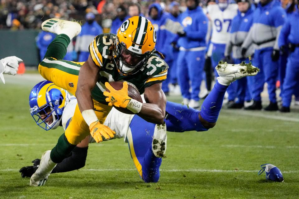 Green Bay Packers running back Aaron Jones (33) dives for a touchdown against the Los Angeles Rams in the second half of an NFL football game in Green Bay, Wis. Monday, Dec. 19, 2022.