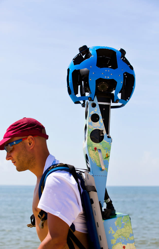 In this photo taken July 30, 2013, and made available by Visit Florida, Chris Officer carries a Google street view camera as he walks recording St. George Island beach in the Florida Panhandle. Visit Florida, the state's tourism agency, partnered with Google in the effort to map all 825 miles of Florida’s beaches. The Florida project is the first large-scale beach mapping project. (AP Photo/Visit Florida, Colin Hackley)