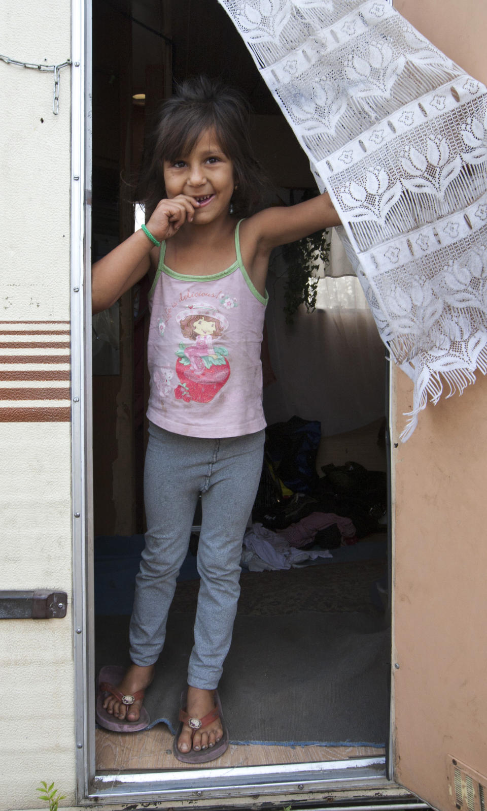 A young girl poses in a Gypsie camp in Wissous, outside Paris, Wednesday Aug. 22, 2012. French Prime Minister Jean-Marc Ayrault was to host a meeting of ministers Wednesday on the issue of Roma, or Gypsies, in France after the government launched its latest campaign this month to drive them from their camps. (AP/Jacques Brinon)