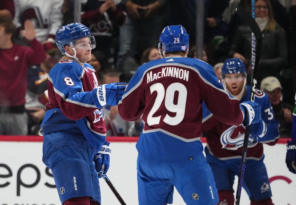 Colorado Avalanche defenseman Cale Makar (8) celebrates a goal with center Nathan MacKinnon (29) as left wing J.T. Compher (37) watches, during the second period of the team's NHL hockey game against the Vancouver Canucks on Wednesday, Nov. 23, 2022, in Denver. (AP Photo/Jack Dempsey)