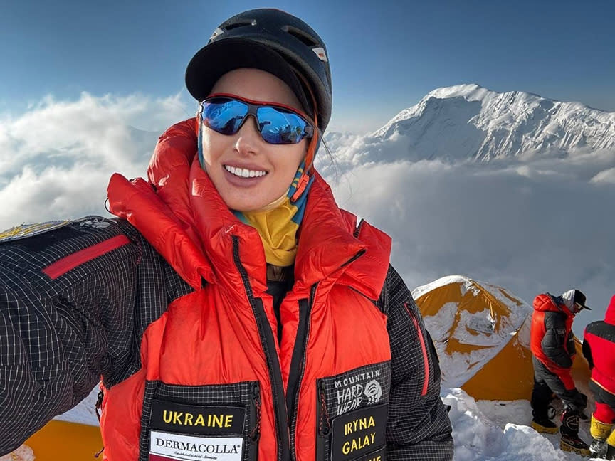 Galay takes a selfie in dawn light, with low clouds behind and a snowy peak.