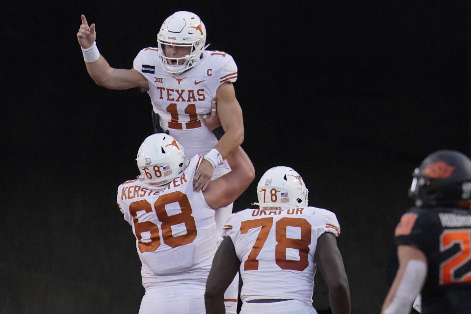 Texas quarterback Sam Ehlinger (11) celebrates a touchdown with offensive lineman Derek Kerstetter (68) and offensive lineman Denzel Okafor (78) in front of Oklahoma State linebacker Malcolm Rodriguez (20) during the second half of an NCAA college football game in Stillwater, Okla., Saturday, Oct. 31, 2020. (AP Photo/Sue Ogrocki)