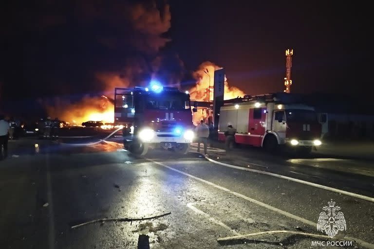 En esta imagen del servicio de prensa del Ministerio de Situaciones de Emergencia de Rusia, los bomberos intentan extinguir un incendio en una gasolinera en una carretera cerca de Makhachkala