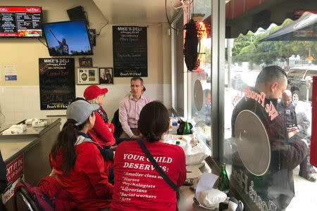 Los Angeles Mayor Eric Garcetti sits at a deli counter and talks with striking teachers in downtown Los Angeles, California, U.S., January 15, 2019. REUTERS/Alex Dobuzinskis