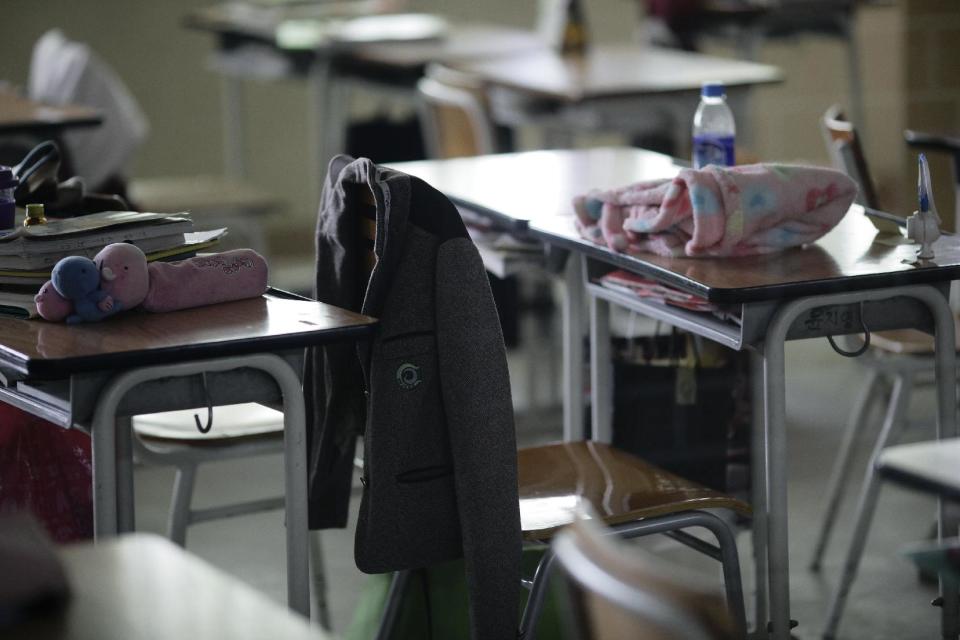 Personal items belonging to students who were on the sinking ferry sit inside an empty classroom of Danwon High School in Ansan, South Korea, Thursday, April 17, 2014. Strong currents, rain and bad visibility hampered an increasingly anxious search Thursday for 287 passengers, many thought to be high school students, still missing more than a day after their ferry flipped onto its side and sank in cold waters off the southern coast of South Korea. (AP Photo/Woohae Cho)