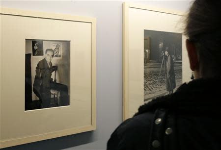 A journalist looks at a picture named 'Autoportrait 1930' (L) by photographer Brassai (1899-1984) displayed at the exhibition "Brassai - For the Love of Paris" at Paris City Hall November 6, 2013. REUTERS/Jacky Naegelen