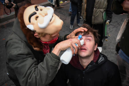 A woman helps a protester after he was sprayed with pepper spray during protest near the inauguration of President-elect Donald Trump in Washington, DC, U.S., January 20, 2017. REUTERS/Bryan Woolston