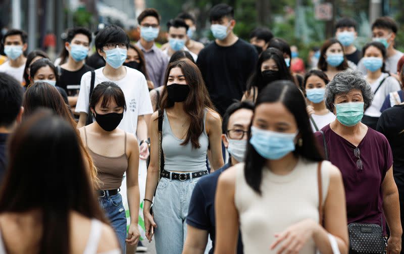 FILE PHOTO: People cross a street at the shopping district of Orchard Road as the city state reopens the economy, amid the coronavirus disease (COVID-19) outbreak, in Singapore