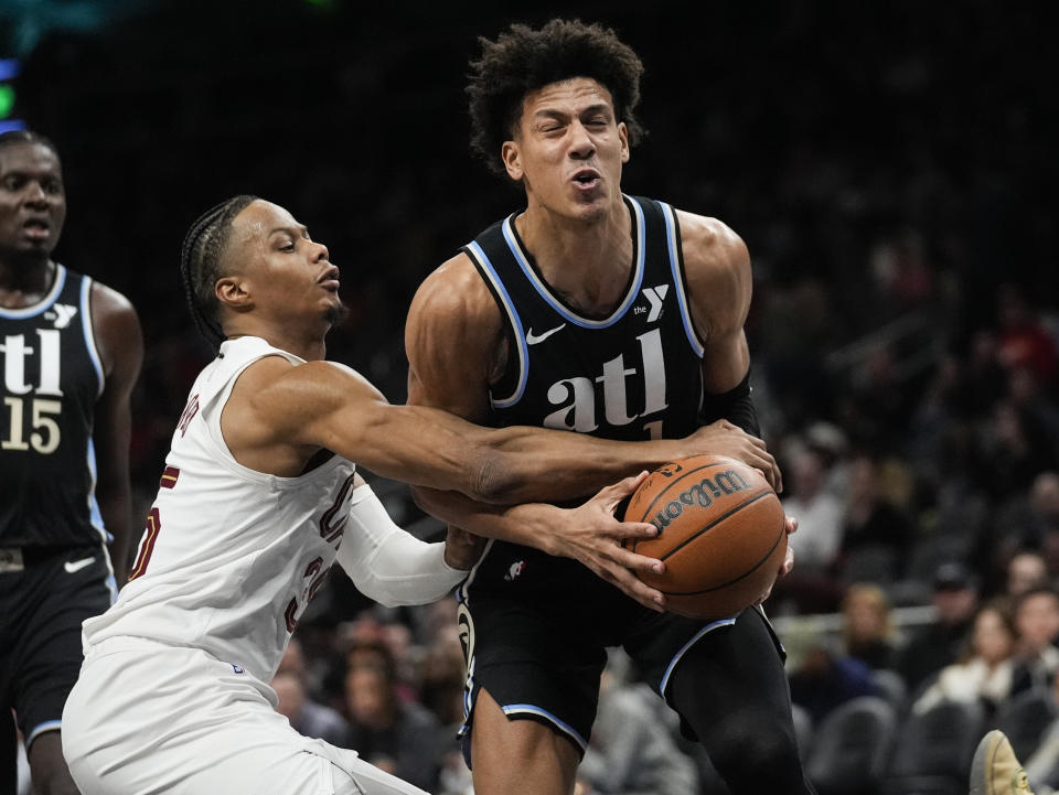 Atlanta Hawks forward Jalen Johnson (1) is defended by Cleveland Cavaliers forward Isaac Okoro (35) as he goes to the basket during the first half of an NBA basketball game Wednesday, March 6, 2024, in Atlanta. (AP Photo/John Bazemore)