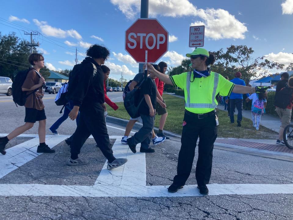 Sana Foster (in bright yellow shirt) on Nov. 7, 2023, works as a school crossing guard with Port St. Lucie Police at Oak Hammock K-8 School at Southwest Savona and Southwest California boulevards in Port St. Lucie.