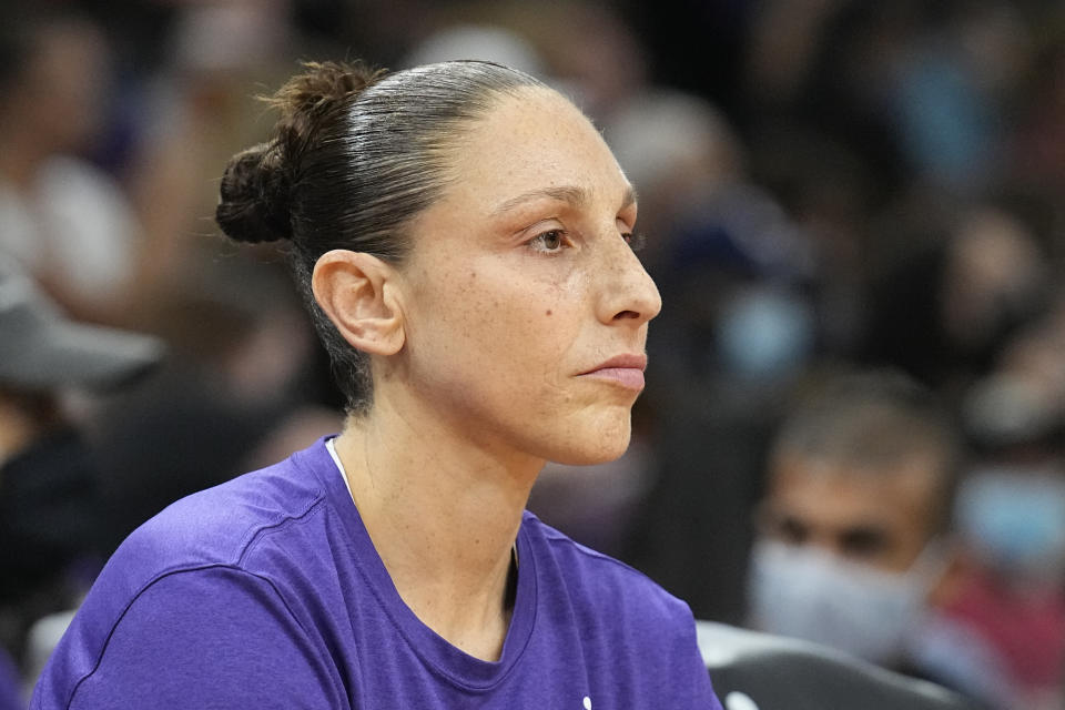 Diana Taurasi stares out with an intense look on her face while sitting on the bench.