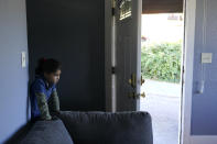 One of the four children of Abdul (not shown), who worked as a mechanic before he left Kabul, Afghanistan with his family about a month ago, peers out from a staircase, Thursday, Sept. 16, 2021, in the rental house the family has been provided as a place to stay in Seattle. The home is owned by Thuy Do, who was nine years old when her family arrived in the United States from Vietnam in the 1980s. Now Do and her husband have offered their vacant rental home to refugee resettlement groups to house newly arriving Afghans in need of a place to stay. (AP Photo/Ted S. Warren)