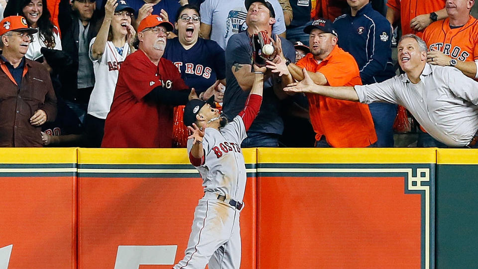 A fan interferes with Mookie Betts as he attempts to catch the ball. (Photo by Bob Levey/Getty Images)