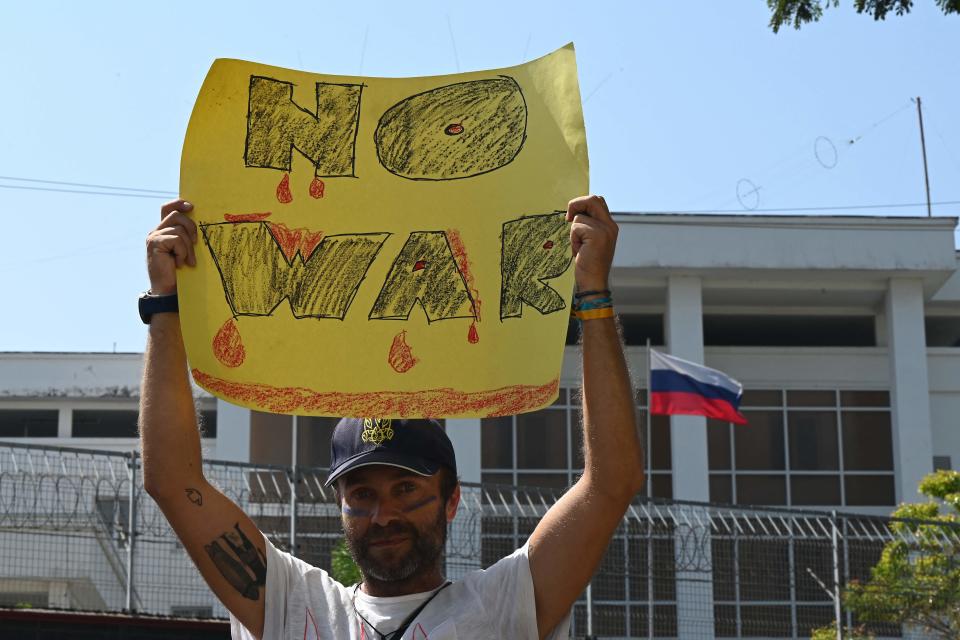 A demonstrator holds a placard reading 'no war' during a protest against Russia's invasion of Ukraine, in front of the Russian embassy in Colombo on February 28, 2022.