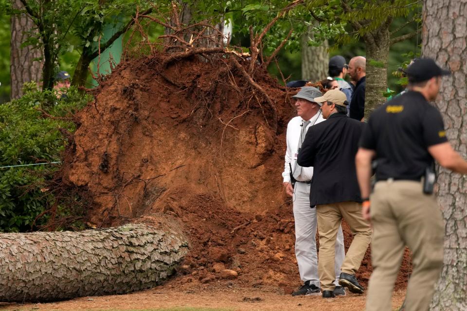 Volunteers and staff secure the area around where three trees fell Friday near the 17th hole during the second round of the Masters. No one was injured.
