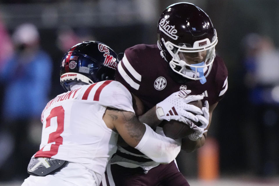 Mississippi State wide receiver Justin Robinson is tackled by Mississippi safety Daijahn Anthony, left, during the first half of an NCAA college football game in Starkville, Miss., Thursday, Nov. 23, 2023. (AP Photo/Rogelio V. Solis)