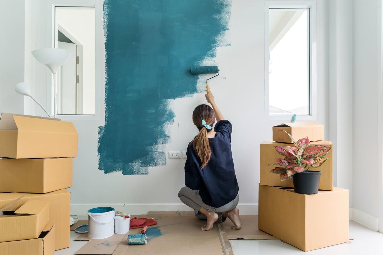 Woman painting interior of her house