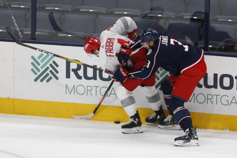 Detroit Red Wings' Robby Fabbri, left, and Columbus Blue Jackets' Seth Jones fight for a loose puck during the first period of an NHL hockey game Tuesday, March 2, 2021, in Columbus, Ohio. (AP Photo/Jay LaPrete)