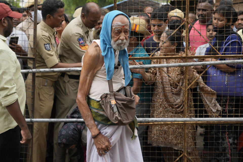 An asthma patient arrives to receive a fish therapy as others stand in a queue, in Hyderabad, India, Saturday, June 8, 2024. Every year thousands of asthma patients arrive here to receive this fish therapy from the Bathini Goud family, a secret formula of herbs, handed down by generations only to family members. The herbs are inserted in the mouth of a live sardine, or murrel fish, and slipped into the patient's throat. (AP Photo/Mahesh Kumar A.)