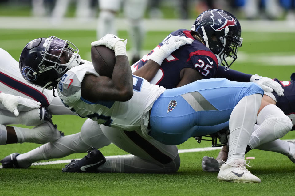 Tennessee Titans tight end Chigoziem Okonkwo (85) is tackled by Houston Texans cornerback Desmond King II (25) during the first half of an NFL football game Sunday, Dec. 31, 2023, in Houston. (AP Photo/David J. Phillip)