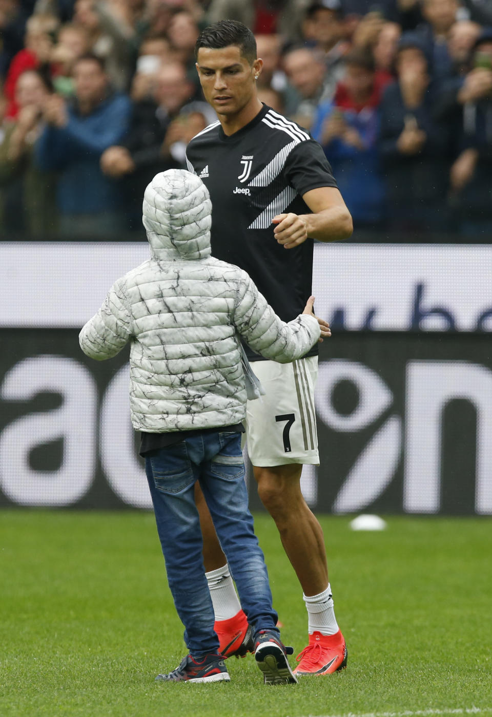 Juventus forward Cristiano Ronaldo talks with a young Juventus fan prior to the Serie A soccer match between Udinese and Juventus, at the Dacia Arena stadium in Udine, Italy, Saturday, Oct.6, 2018. (AP Photo/Antonio Calanni)