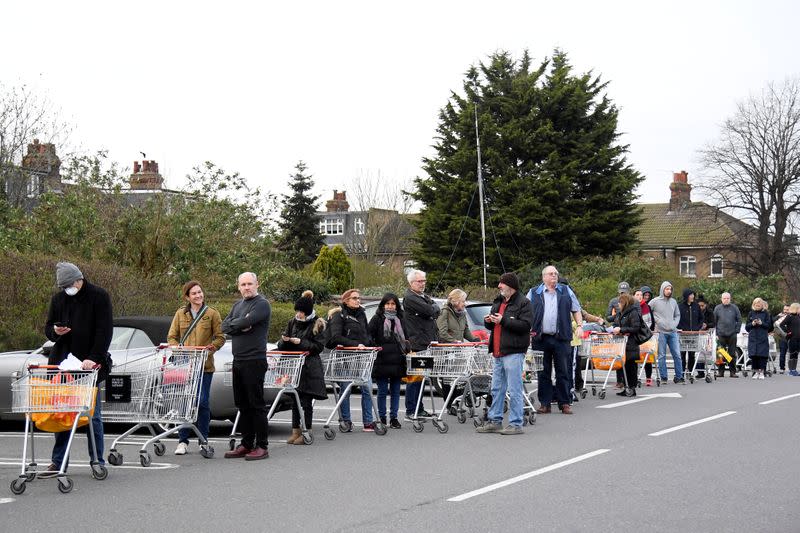 FILE PHOTO: Shoppers queue to enter a Sainsbury's supermarket in West London