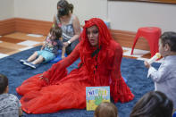 A drag queen who goes by the name Flame reads stories to children and their caretakers during a Drag Story Hour at a public library in New York, Friday, June 17, 2022. (AP Photo/Seth Wenig)