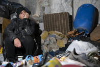 Hoda, 57, a Lebanese garbage scavenger, sits in her home in Sabra and Shatila Camp surrounded by items she picked from garbage, in Beirut, Lebanon, Wednesday, Jan. 12, 2022. As Lebanon faces one of the world’s worst financial crises in modern history, now even its trash has become a commodity fought over in the street. (AP Photo/Lujain Jo)