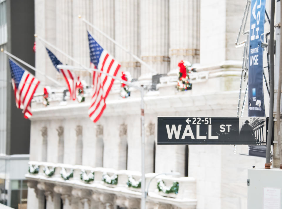 NEW YORK, NEW YORK - DECEMBER 18: The Wall Street street sign is visible against the New York Stock Exchange on December 18, 2020 in New York City. The pandemic has caused long-term repercussions throughout the tourism and entertainment industries, including temporary and permanent closures of historic and iconic venues, costing the city and businesses billions in revenue. (Photo by Noam Galai/Getty Images)