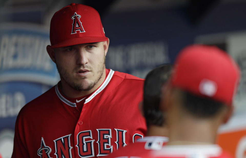 Los Angeles Angels' Mike Trout stands in the dugout during the third inning of a baseball game against the Cleveland Indians, Saturday, Aug. 4, 2018, in Cleveland. Trout's right wrist is still sore and the Angels will not risk him making it any worse. (AP Photo/Tony Dejak)