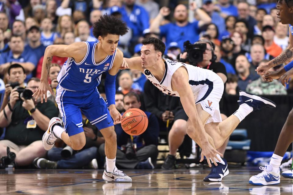 Duke guard Tyrese Proctor (5) dribbles past Virginia center Francisco Caffaro (22) during the first half of the 2023 ACC tournament championship game at Greensboro Coliseum.