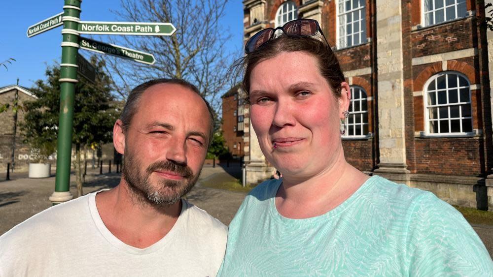 Gary Davies in a white t-shirt, and his partner Lisa Johns in a blue top, standing outside