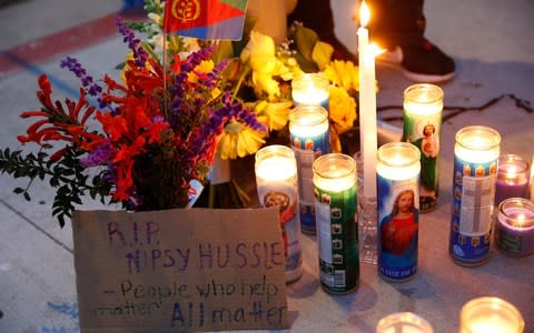 People gathered outside the shop and lit candles in tribute - Credit: AP Photo/Damian Dovarganes