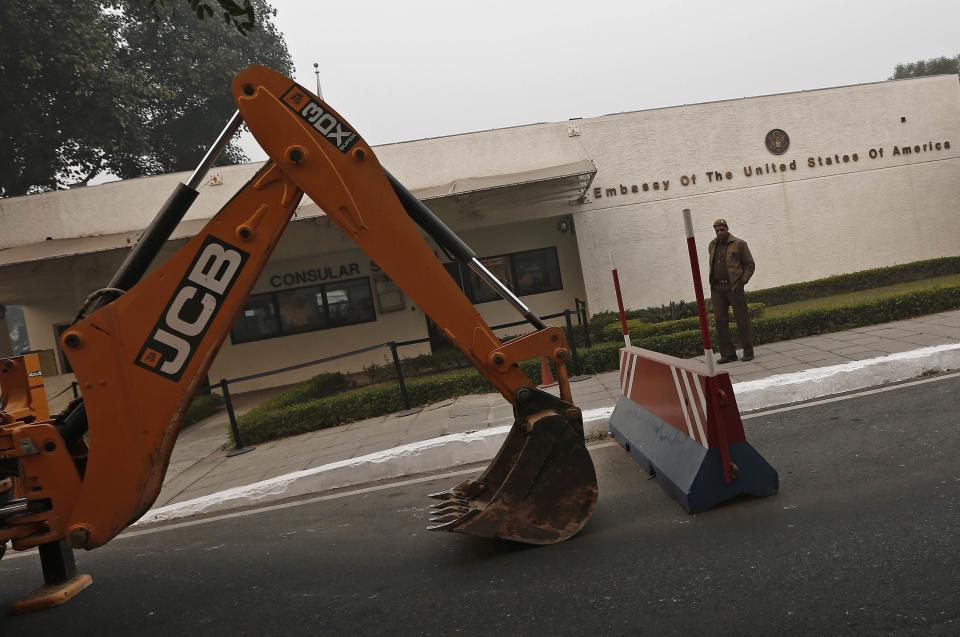 A policeman stands next to a bulldozer removing the security barriers in front of the U.S. embassy in New Delhi December 17, 2013. Indian authorities removed security barriers in front of the U.S. embassy in New Delhi on Tuesday apparently in retaliation for the arrest and alleged heavy-handed treatment of an Indian diplomat in New York. New Delhi police used tow trucks and bulldozers to remove the concrete barricades, which are used to restrict traffic on the road outside the embassy. REUTERS/Adnan Abidi (INDIA - Tags: POLITICS)