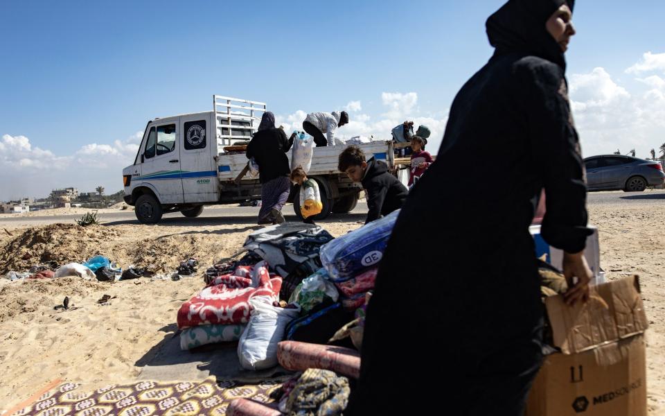 Displaced Palestinians from the Al-Bilbisi family collect their belongings to leave the Rafah camp in the southern Gaza Strip