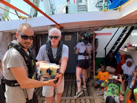 U.S. actor Gere helps to carry supplies aboard Open Arms recues boat at Mediterranean sea in this picture provided by the Spanish NGO