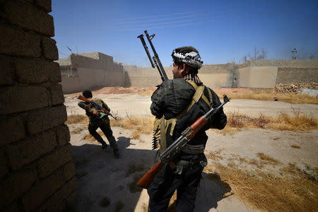 Shi'ite Popular Mobilization Forces (PMF) members clash with Islamic State militants at Al Jazeera neighborhood of Tal Afar, Iraq. REUTERS/Stringer