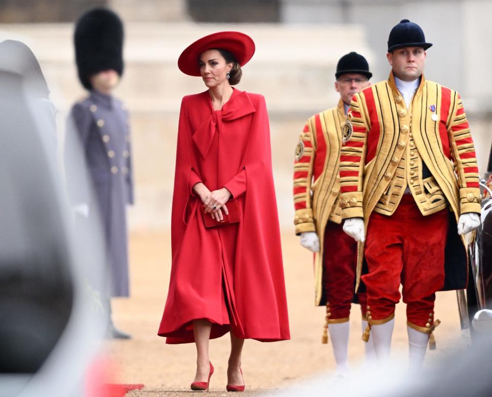 Kate Middleton walks in a red coat dress.