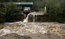 A home and car are stranded after a flash flood in Coal Creek destroyed the bridge near Golden, Colorado September 12, 2013. Flooding in Colorado left two people dead, prompted hundreds to be evacuated, caused building collapses and stranded cars, officials said. REUTERS/Rick Wilking (UNITED STATES - Tags: DISASTER ENVIRONMENT TPX IMAGES OF THE DAY)