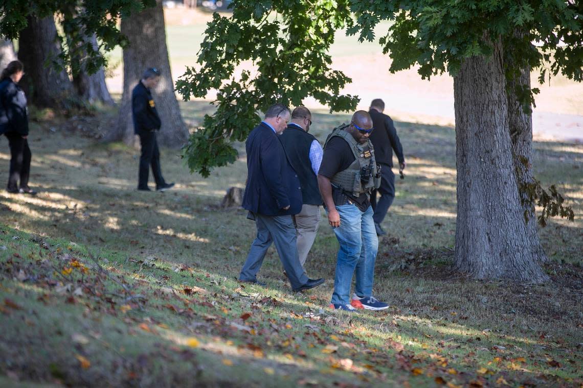 Raleigh Police detectives look for evidence along the golf course in the Hedingham neighborhood on Friday morning, October 14, 2022 in Raleigh, N.C. as they continue to investigate the shooting that killed 5 people, including an off-duty police officer.