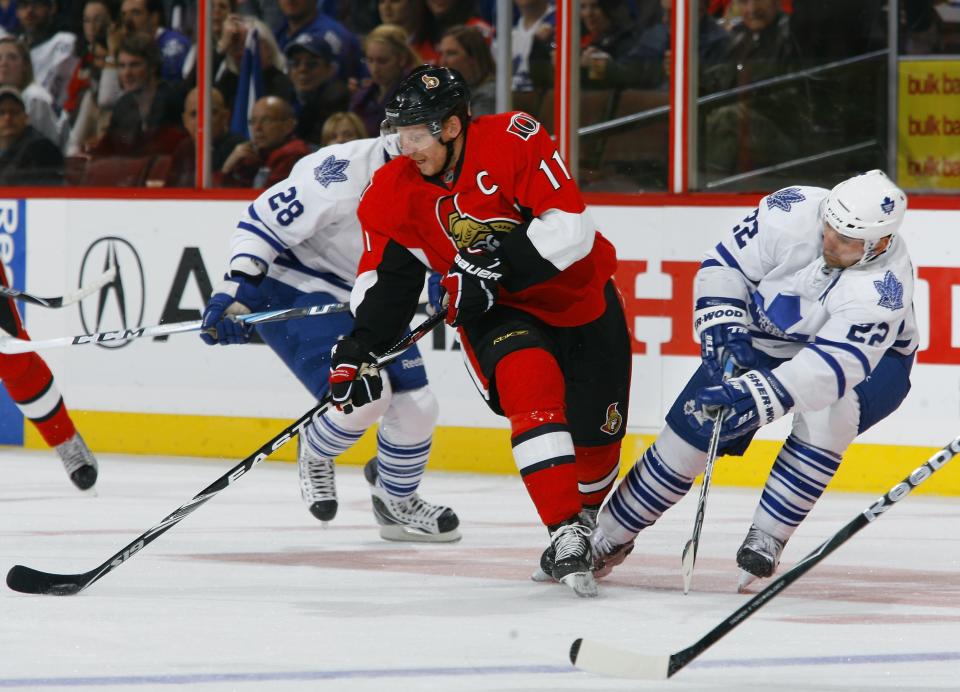 OTTAWA, ON - NOVEMBER 27: Daniel Alfredsson #11 of the Ottawa Senators dekes betwen Colton Orr #28 and Francois Beauchemin #22 of the Toronto Maple Leafs with the puck during a game at Scotiabank Place on November 27, 2010 in Ottawa, Ontario, Canada. (Photo by Phillip MacCallum/Getty Images)