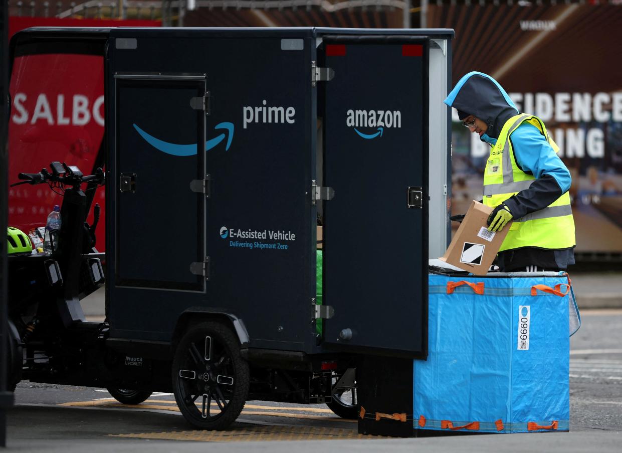 A man sorts parcels at the back of an Amazon delivery vehicle in Manchester, Britain, November 26, 2022. REUTERS/Phil Noble