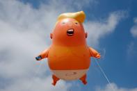 <p>A giant balloon inflated by activists depicting President Donald Trump as an orange baby is seen during a demonstration against Trump’s visit to the UK in Parliament Square in London on July 13, 2018. (Photo: Tolga Akmen/AFP/Getty Images) </p>