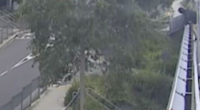 Trying to avoid an arrest, the man peers over the ledge of a carpark rooftop. Source: 7 News