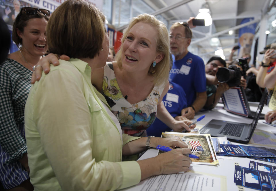 Democratic presidential candidate Sen. Kirsten Gillibrand, D-N.Y. right, embraces Democratic presidential candidate Sen. Amy Klobuchar, D-Minn., at a booth at the Iowa State Fair, Saturday, Aug. 10, 2019, in Des Moines, Iowa. (AP Photo/John Locher)