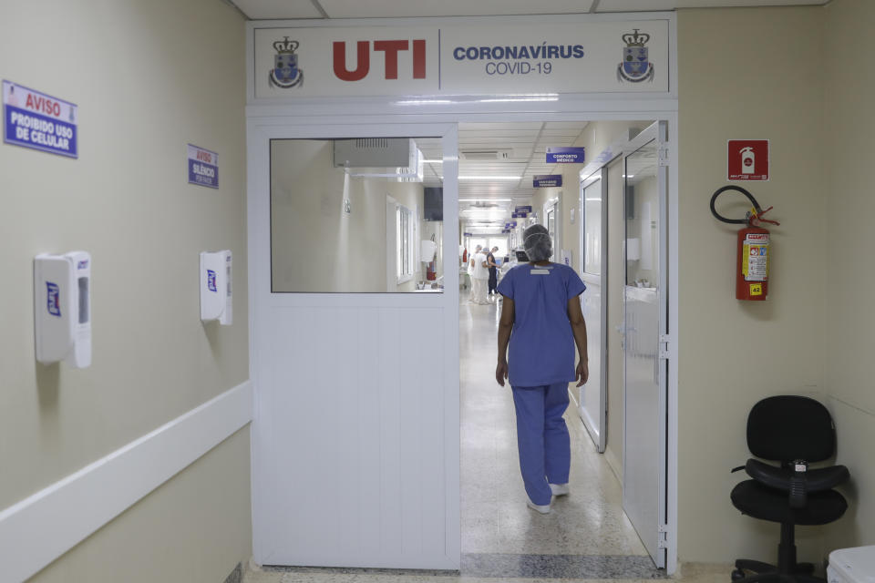 A health worker walks into the intensive care unit at the Santa Casa Hospital in Jau, Brazil, Thursday, Jan. 28, 2021. The hospital is operating at full capacity due to COVID-19 and patients need to take turns receiving oxygen. (AP Photo/Andre Penner)