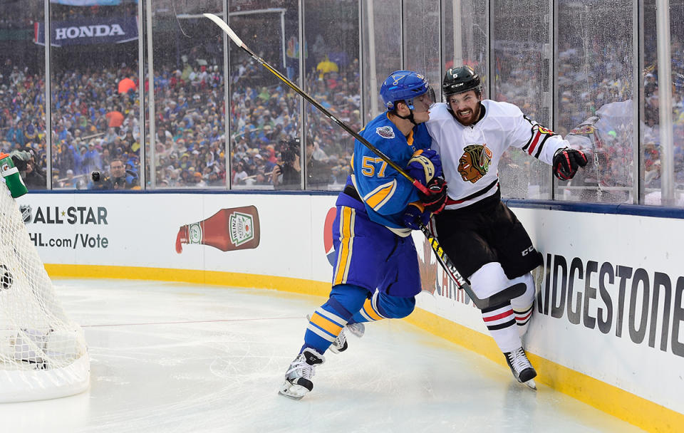 <p>ST LOUIS, MO – JANUARY 02: David Perron #57 of the St. Louis Blues checks Michal Kempny #6 of the Chicago Blackhawks near the end boards during the 2017 Bridgestone NHL Winter Classic at Busch Stadium on January 2, 2017 in St Louis, Missouri. (Photo by Patrick McDermott/NHLI via Getty Images) </p>