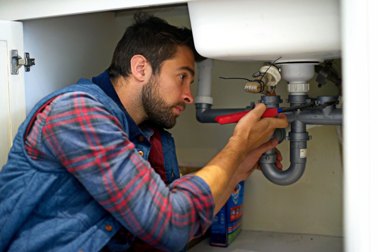 plumber with focused look fixing sink