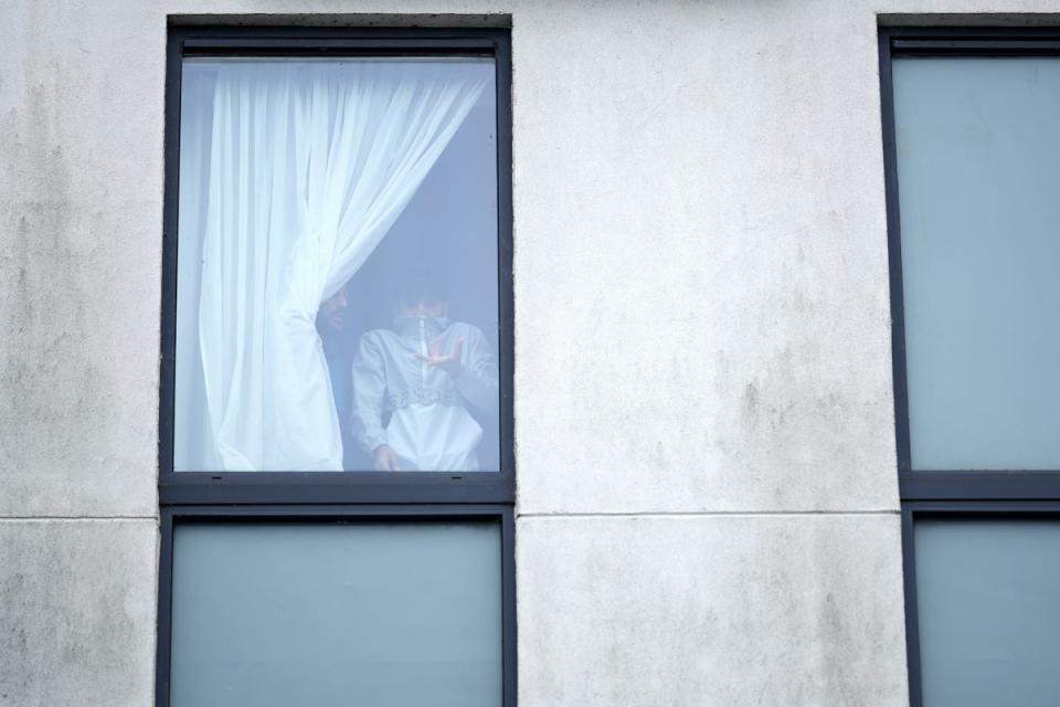 A man looks out of a window as rioters attack a hotel housing migrants in Rotherham (Getty Images)